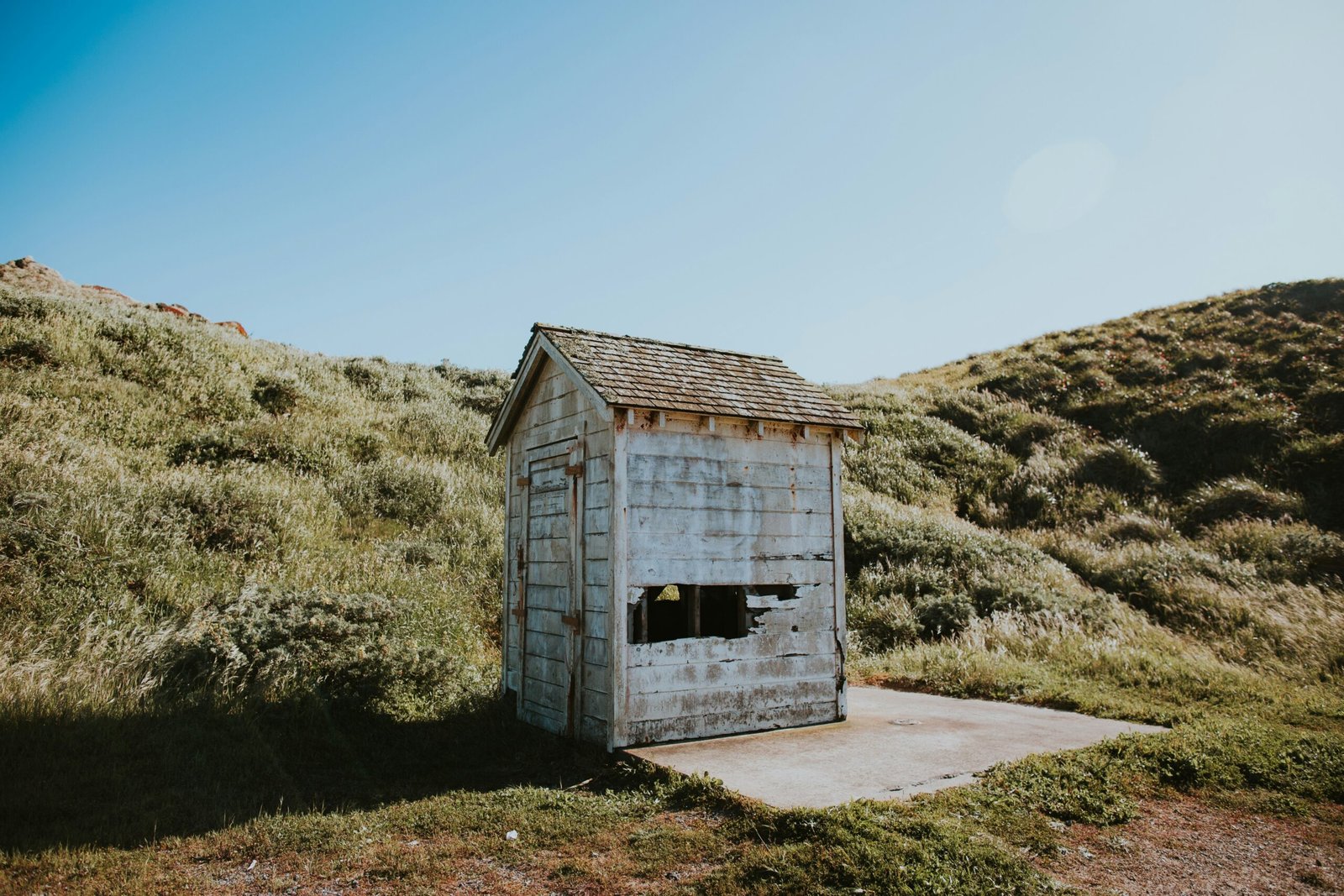 shed on grass field under cumulus clouds